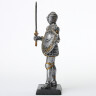 Figure of an armored knight in armet with sword and buckeled shield