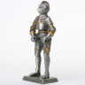 Tin knight statue in gilded armor with sword