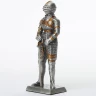 Tin knight statue in gilded armor with besagews