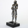 Figure of a knight in chain mail armor and steel full-suit armor